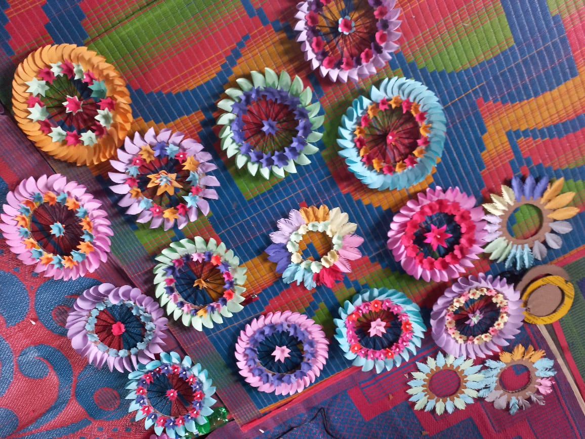 Colourful paper mandalas made by Colour Point students, laid out on a woven mat
